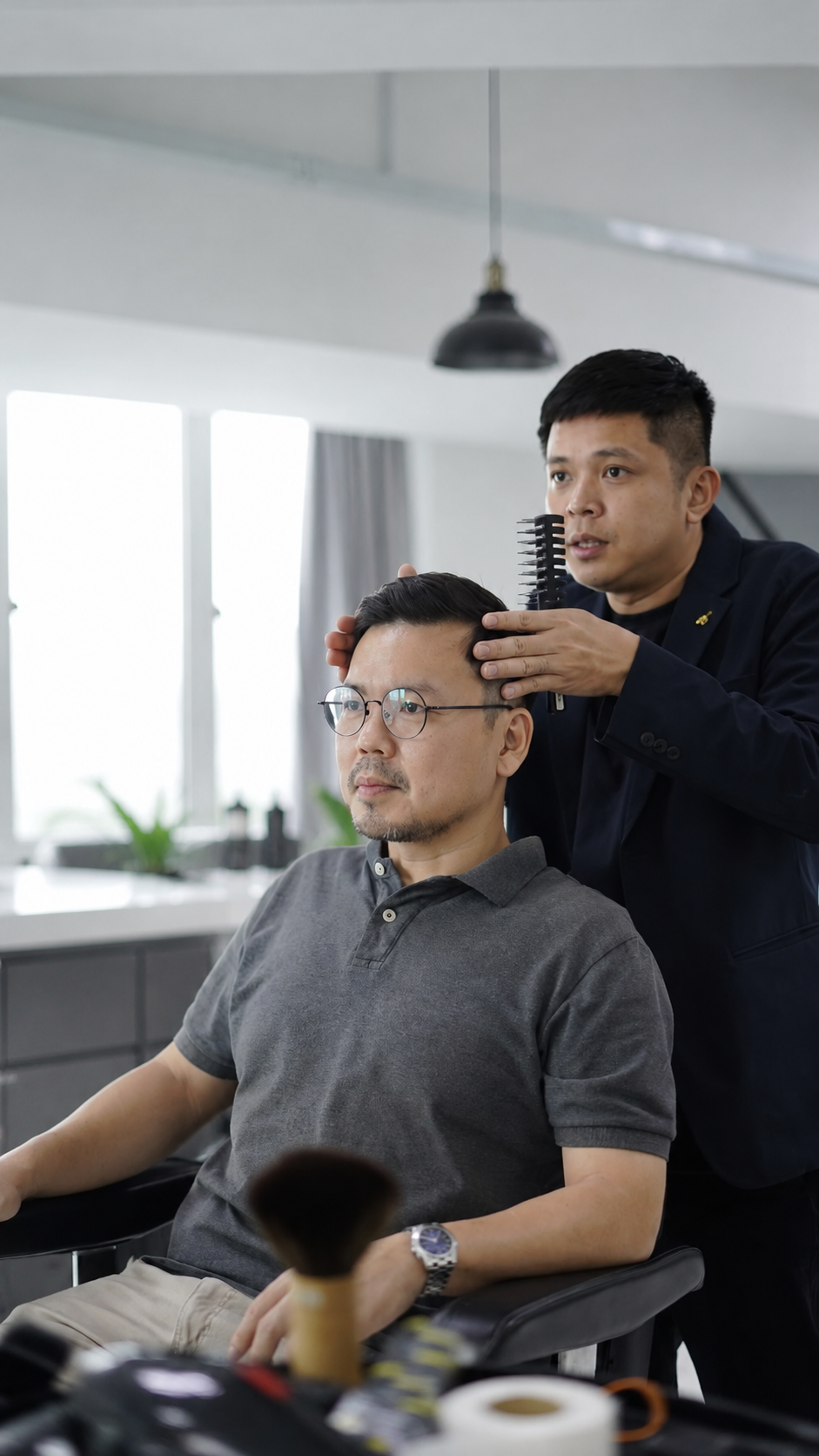 Barber styling a client's hair at Othrs Barbers